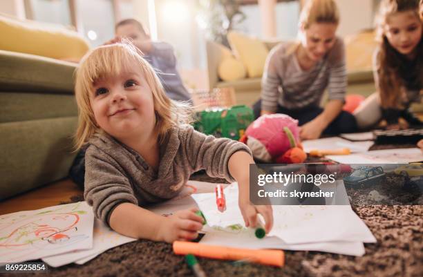 lachende jongen plezier terwijl kleuren in de woonkamer. - babysit stockfoto's en -beelden