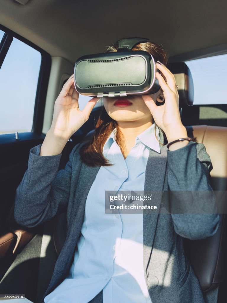 Businesswomen with VR glasses in car