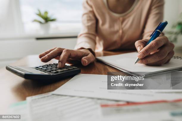 feche de mulher planejamento orçamento em casa e usar a calculadora. - instrumento financeiro - fotografias e filmes do acervo