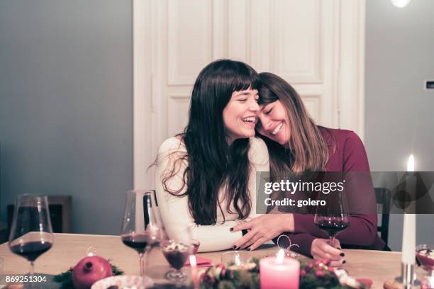 young beautiful sibling sisters close together at christmas table - sibling christmas stock pictures, royalty-free photos & images