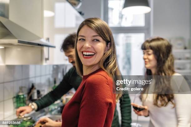 junge glückliche menschen, gemeinsames kochen in der küche - xmas together stock-fotos und bilder