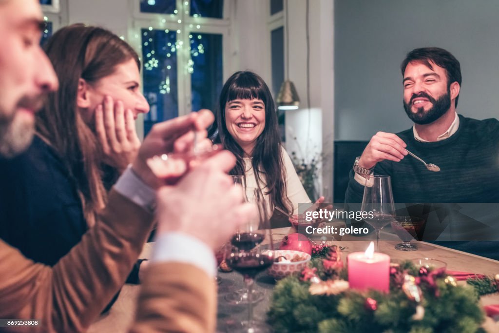 Young happy people talking at christmas table