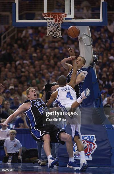 Guard Gerald Fitch of the Kentucky Wildcats takes a shot as he collides with forward Jack Ingram of the Tulsa Golden Hurricanes during the second...