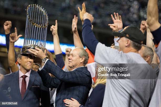 Houston Astros owner Jim Crane hoists the Commissioner's Trophy after the Astros defeated the Los Angeles Dodgers in Game 7 of the 2017 World Series...