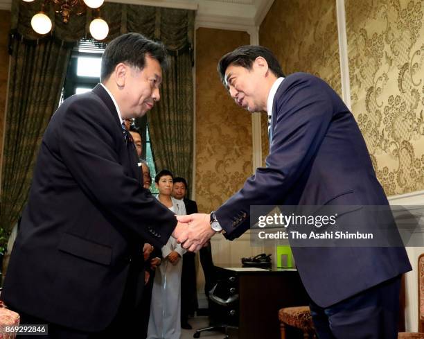 Re-elected Prime Minister Shinzo Abe shakes hands with the Constitutional Democratic Party leader Yukio Edano prior to their meeting at the Diet...