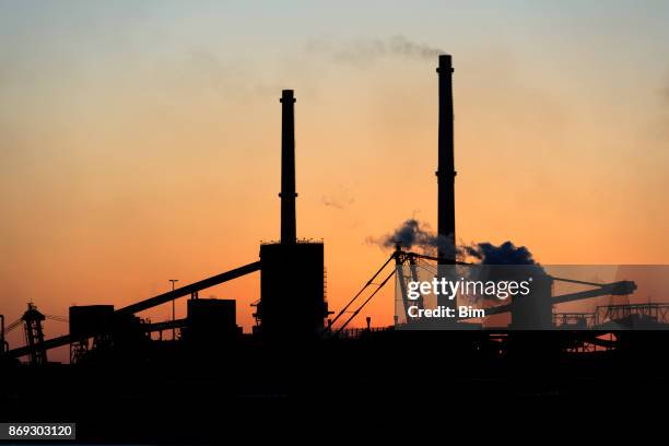 silhouette of industrial plant against sunset sky - steel mill stock pictures, royalty-free photos & images