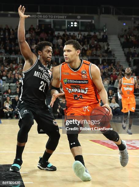 Michael Carrera of the Cairn Taipans is challenged by Casper Ware of the Melbourne United during the round five NBL match between Melbourne United...