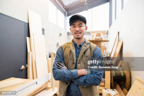 portrait of carpenter in workshop - platte pet stockfoto's en -beelden