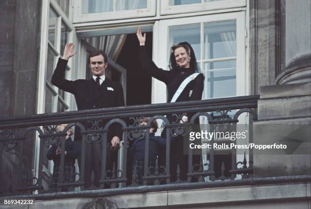 Queen Margrethe II of Denmark pictured with her husband Henrik, Prince Consort of Denmark as they wave to crowds from a balcony at Christiansborg...