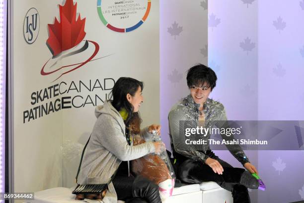 Shoma Uno of Japan waits for his score with his coach Mihoko Higuchi at the kiss and cry after competing in the Men's Singles Short Program during...