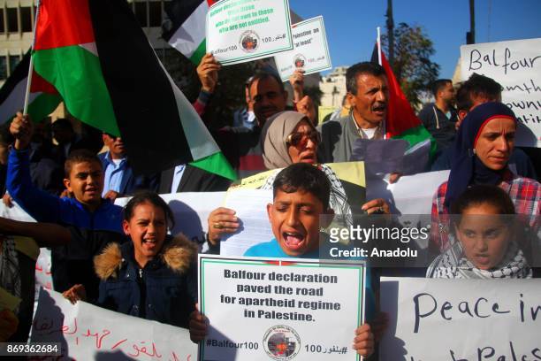 People hold banners during a protest against the Balfour declaration during its 100th anniversary in Hebron, West Bank on November 2, 2017.