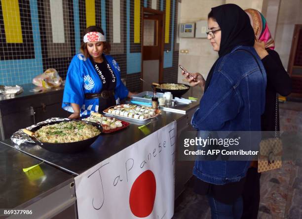Libyan stand at a Japanese food stall during the Libya Comic Convention, in the capital Tripoli on November 2, 2017. / AFP PHOTO / MAHMUD TURKIA