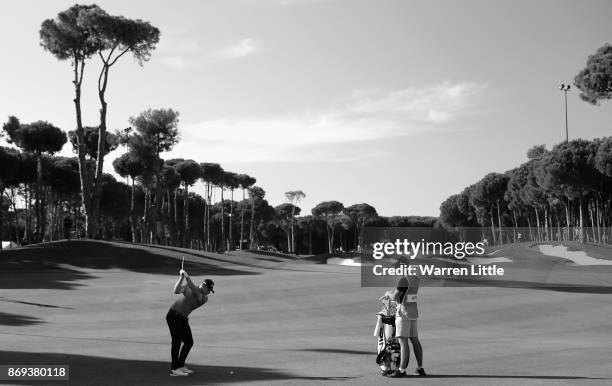 Tyrrell Hatton of England plays his second shot into the 12th green during the first round of the Turkish Airlines Open at the Regnum Carya Golf &...