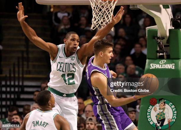 Sacramento Kings guard Bogdan Bogdanovic looks for an outlet as Boston Celtics forward Al Horford swoops in on defense during the first quarter. The...