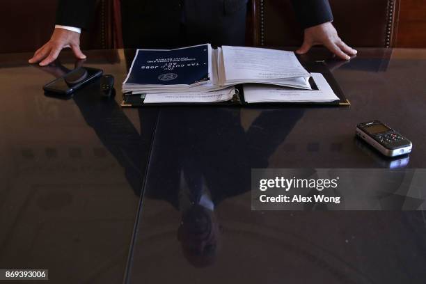 As his reflection is seen on a piece of table-top glass, Chairman of House Ways and Means Committee Rep. Kevin Brady speaks during a news briefing on...