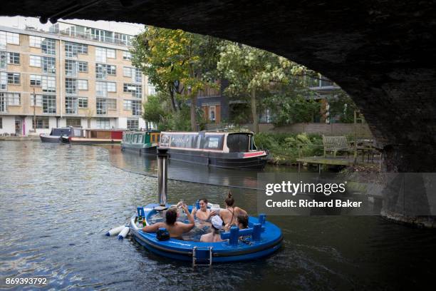 Women float along the cold waters of the Regents Canal in a hot tub from the company HotTug, on 22nd October, in London, England. The HotTug is a...