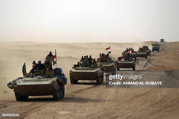 Iraqi forces and members of the Hashed al-Shaabi advance towards the city of al-Qaim, in western Anbar province, on the Syrian border as they fight...