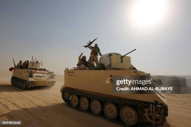 Iraqi forces and members of the Hashed al-Shaabi advance towards the city of al-Qaim, in western Anbar province, on the Syrian border as they fight...