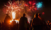 People standing  in front of colorful Firework