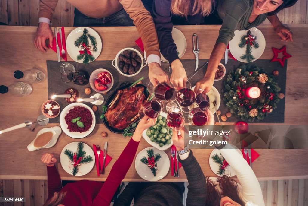 Mensen rammelende wijn glazen op kerst tafel
