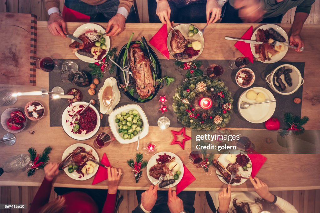 People eating traditional christmas meal at festive wooden table