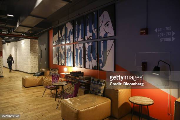 Art hangs above seating in a hallway at the WeLive building in New York, U.S., on Tuesday, Oct. 31, 2017. The first two WeLive buildings, in New York...