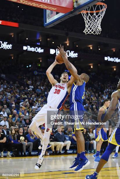 David West of the Golden State Warriors goes up to block the shot of Jon Leuer of the Detroit Pistons during an NBA basketball game at ORACLE Arena...