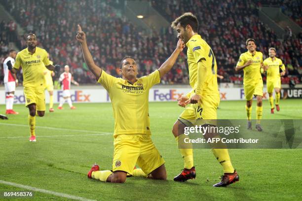 Villarreal's forward from Colombia Carlos Bacca celebrates with teammate midfielder from Spain Manuel Trigueros Munoz after he scored a goal during...