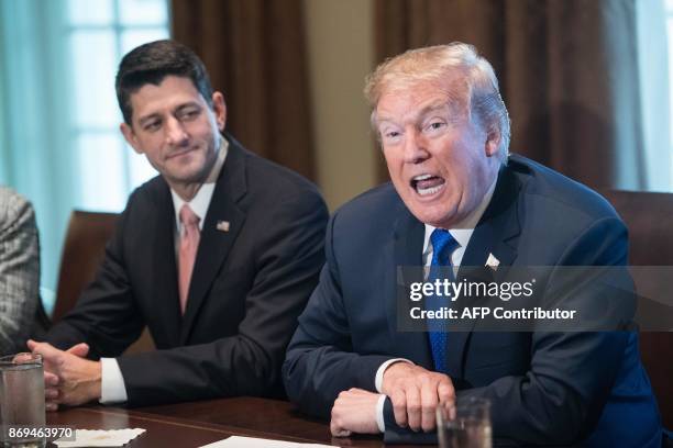 President Donald Trump speaks beside House Speaker Paul Ryan during a meeting with House Republican leaders and Republican members of the House Ways...