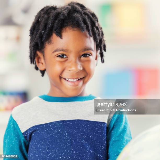 adorable niño en sonrisas de rastas para la cámara en la escuela - dreadlocks fotografías e imágenes de stock