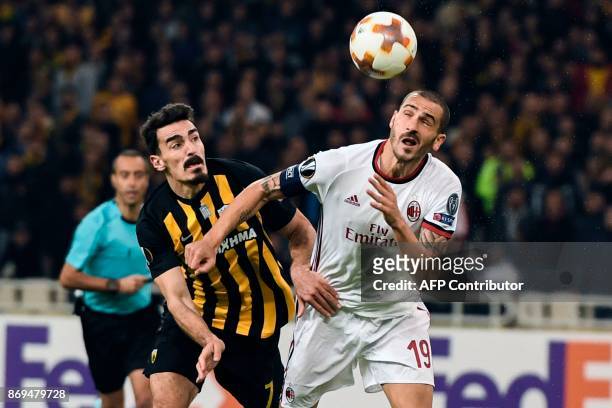 Milan's Leonardo Bonucci vies for the ball with AEK's Lazaros Christodoulopoulos during the UEFA Europa League Group D football match between AEK...
