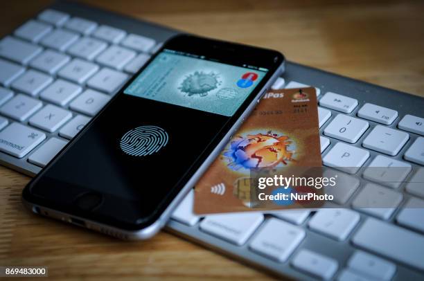 An iPhone and a debit card are seen on November 2, 2017.