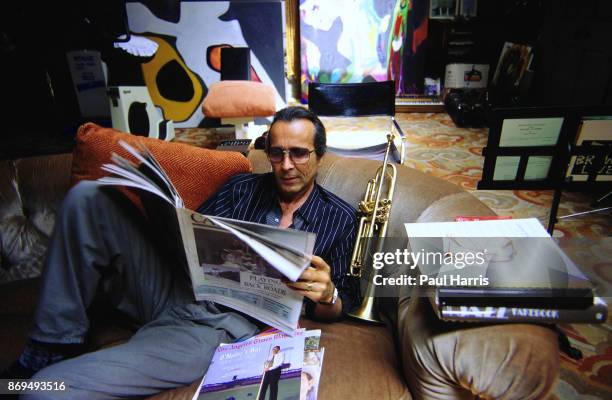 Herb Alpert 47 founder of the Tijuana Brass and A&M records reads a newspaper in the Malibu home he has lived in since 1974 which is on a cliff...