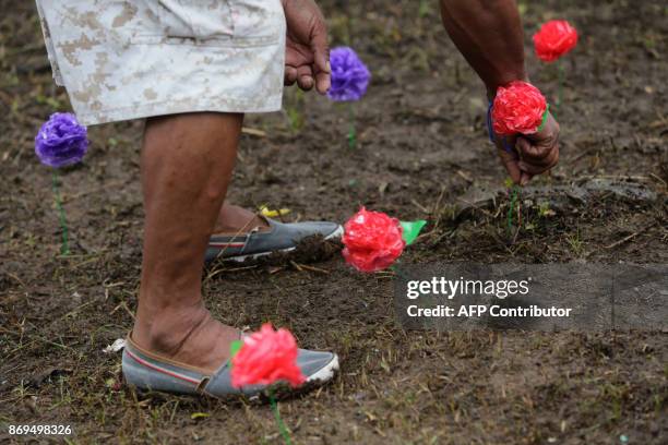 Man places flowers on a grave on the "Day of the Dead" in the cemetery of San Juan del Sur, Rivas, Nicaragua, 130 km from Managua, on November 2,...