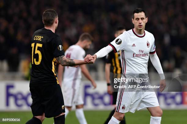 Athens' Uros Cosic and AC Milan's Nikola Kalinic shake hands after the UEFA Europa League Group D football match between AEK Athens and AC Milan at...