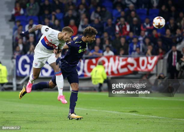 Memphis Depay of Lyon scores the third goal in front of Mason Holgate of Everton during the UEFA Europa League group E match between Olympique...