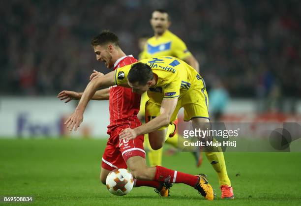 Nikolai Signevich of FC Bate Borisov and Salih Oezcan of FC Koeln battle for posession during the UEFA Europa League group H match between 1. FC...