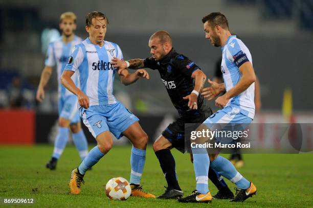 Lucas Leiva and Stefan De Vrij of SS Lazio compete for the ball with Wesley Sneijder of OGC Nice during the UEFA Europa League group K match between...