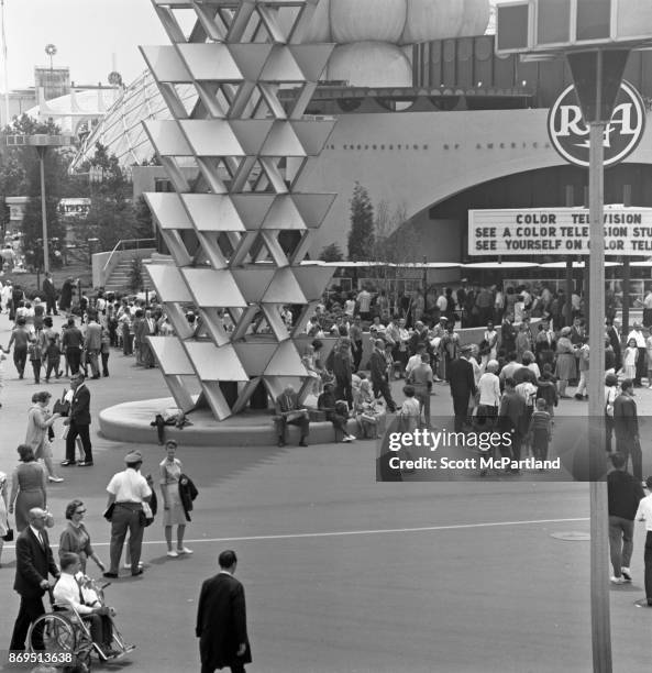 Elevated view of people taking in the sights, and gathering out in front of the RCA Pavilion at the 1964-65 World's Fair in Flushing Meadows Corona...