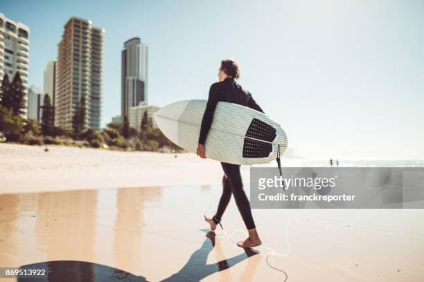 surfer, die zu fuß in surfers paradiesstrand in australien - gold coast australia stock-fotos und bilder