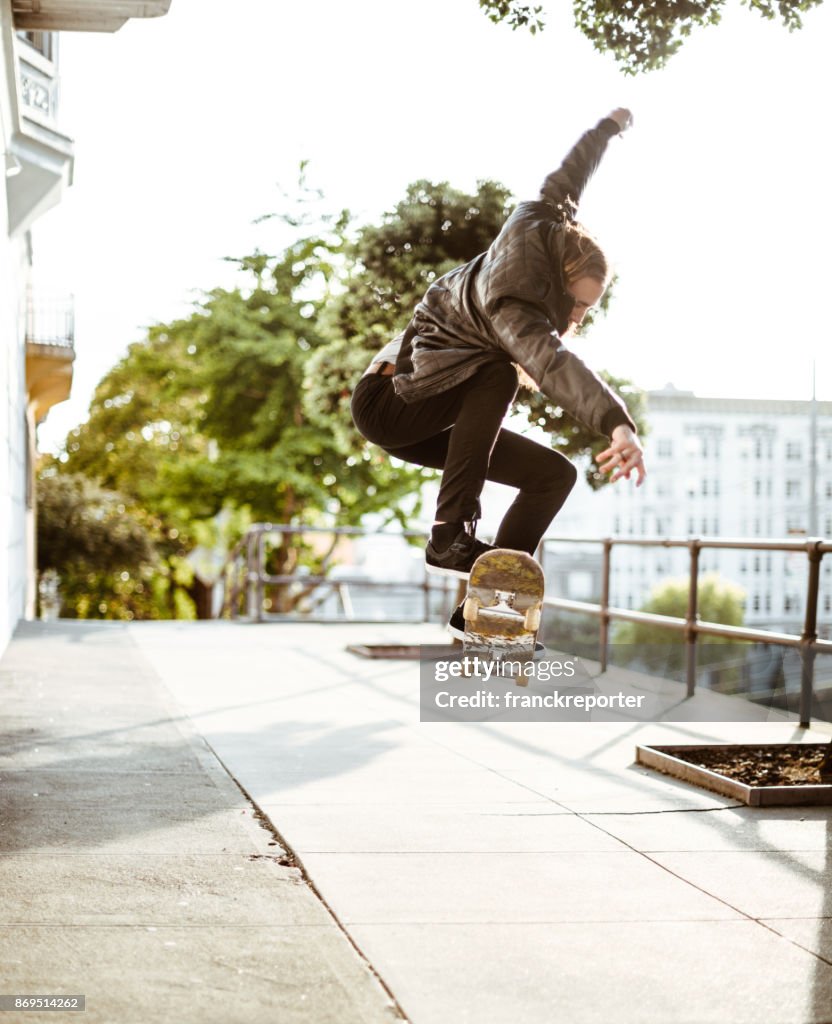 Hipster met zijn skateboard over san francisco