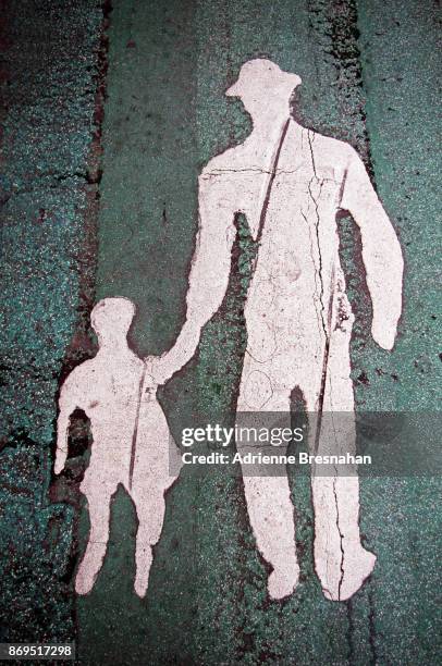 silhouette of man and child walking, painted on the street - taipeh gegenlicht stock-fotos und bilder