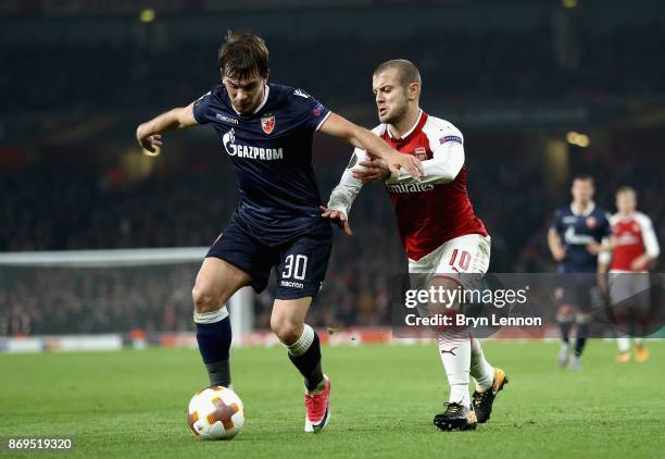 Filip Stojkovic of FK Crvena Zvezda and Jack Wilshere of Arsenal battle for possession during the UEFA Europa League group H match between Arsenal FC...