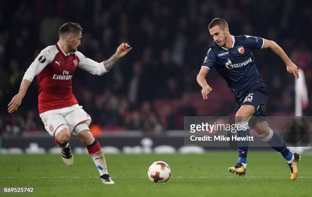 Aleksandar Pesic of FK Crvena Zvezda attempts to get past Mathieu Debuchy of Arsenal during the UEFA Europa League group H match between Arsenal FC...