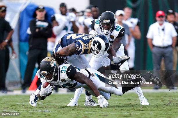 Runningback Chris Ivory of the Jacksonville Jaguars dives for extra yard over Cornerback Trumaine Johnson of the Los Angeles Rams during the game at...