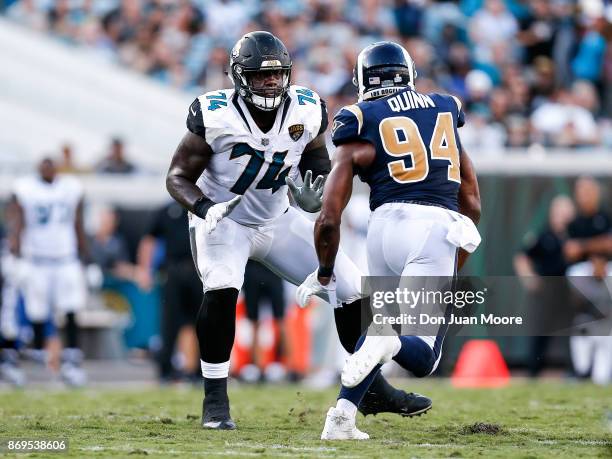 Tackle Cam Robinson of the Jacksonville Jaguars blocks Defensive End Robert Quinn of the Los Angeles Rams during the game at EverBank Field on...