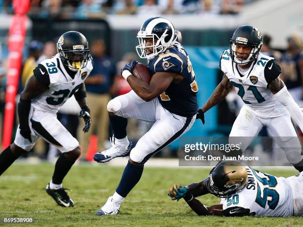 Running back Malcolm Brown of the Los Angeles Rams avoids being tackled by Safety Tashaun Gipson, Linebacker Telvin Smith and Cornerback A.J. Bouye...