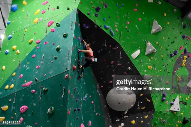 Maureen Beck looks for her next hand holds as she climbs on the overhanging wall at EVO Rock + Fitness Climbing Gym on October 25, 2017 in...