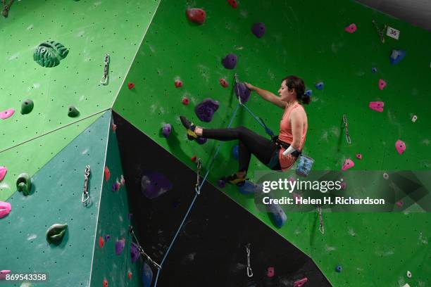 Maureen Beck looks for her next hand holds as she climbs on the overhanging wall at EVO Rock + Fitness Climbing Gym on October 25, 2017 in...