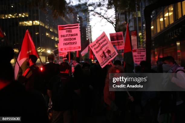 People hold placards during a rally to mark 100th anniversary of Balfour Declaration in support of Palestine next to Israeli House in Manhattan of...